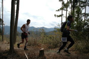 見晴らし台を駆ける選手たち、背後の山はみたけ山
