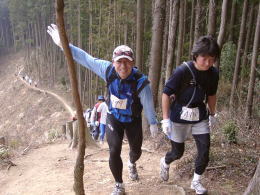 山頂でカメラにサインを送る選手
